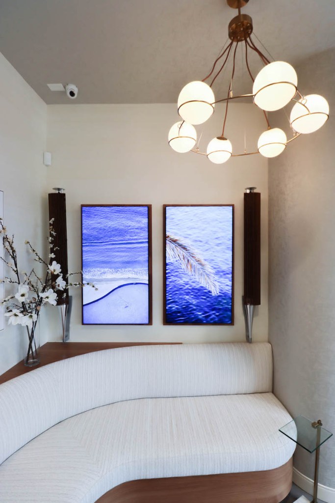 A patient recovery or rest area with a curved white sofa and a wall-mounted TV