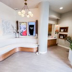 Spacious waiting area showing a long curved bench, white pillars, and contemporary lighting