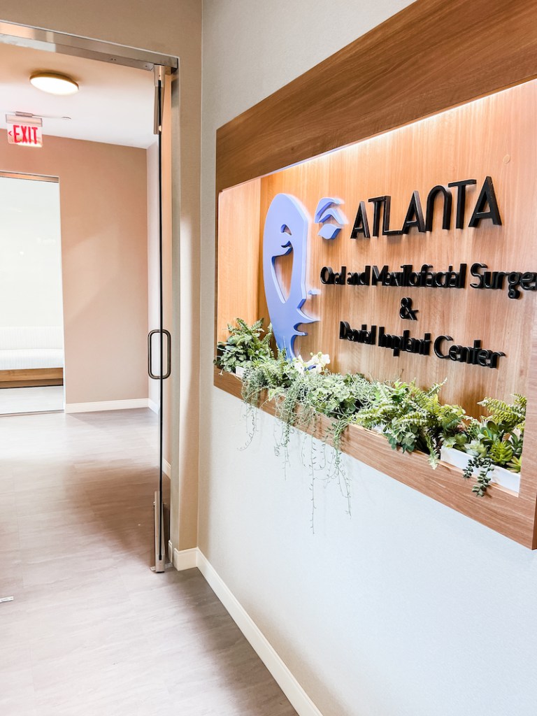 Interior view of the office entrance featuring the same branded signage on a light wood panel