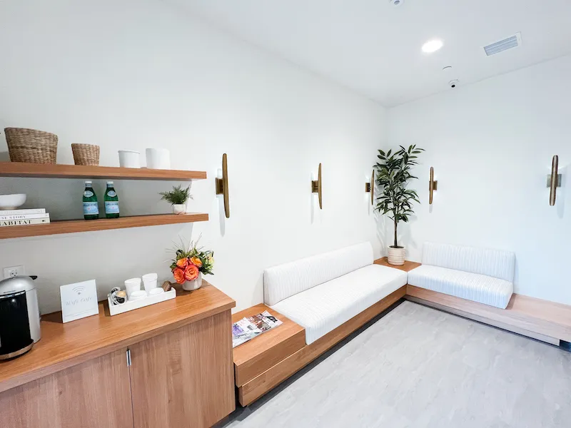 Brightly lit hallway with a seating bench and storage cabinets