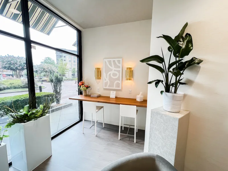 Modern consultation station with two white stools and a large window providing natural light