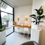 Modern consultation station with two white stools and a large window providing natural light