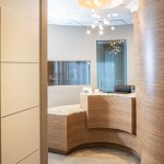 A reception area with sleek wood-paneled walls and a curved wood-grain front desk