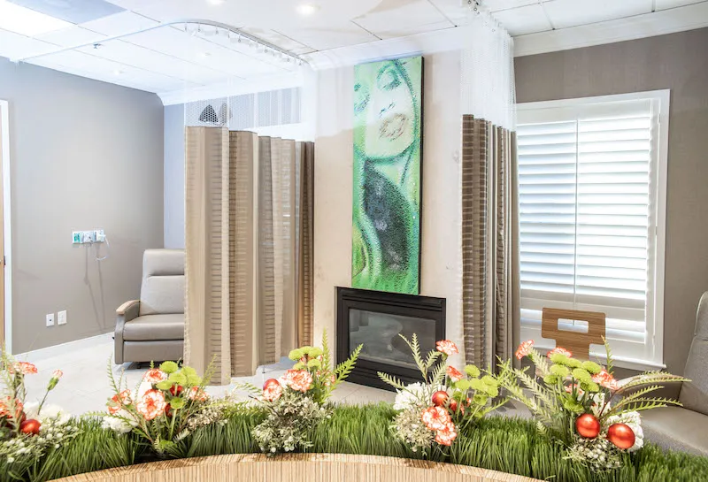 A wide view of the recovery lounge showing privacy screens and a curved planter with decorative flower