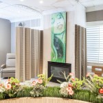 A wide view of the recovery lounge showing privacy screens and a curved planter with decorative flower
