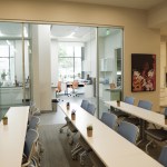 A professional training or meeting room with long white tables and blue office chairs
